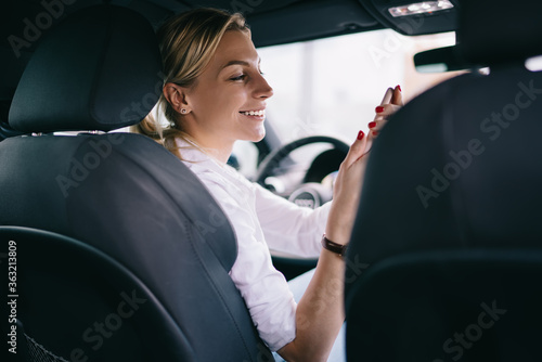 Photography Female driver with smartphone turning to side