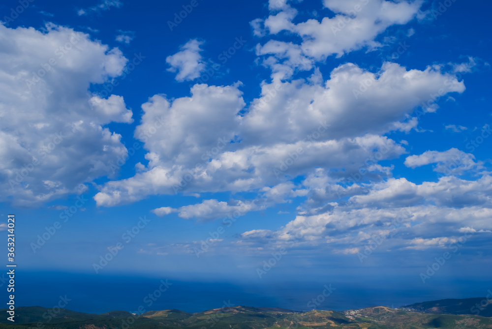 view from a mountain ridge to a sea scape under a cloudy sky