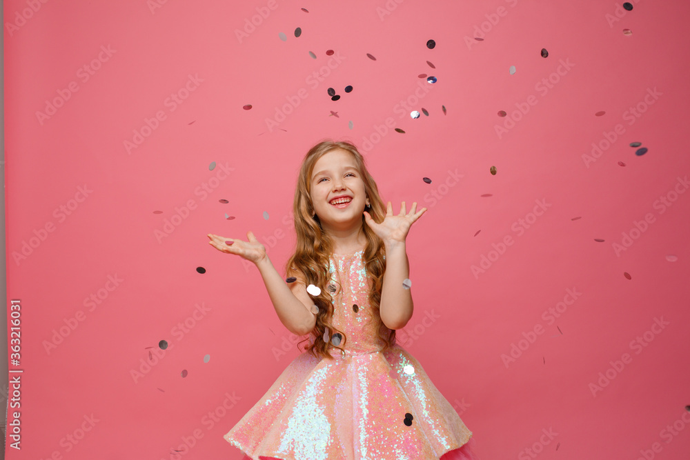 happy Little girl catches confetti on pink background, holiday concept happy Little girl catches confetti on pink background, holiday concept