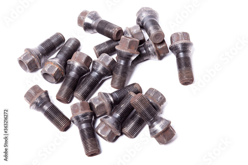 A handful of metal bolts with secret protection to fix the wheels and prevent theft of the car on a white background in a photo studio. Spare consumables for replacement during repair or for sale.