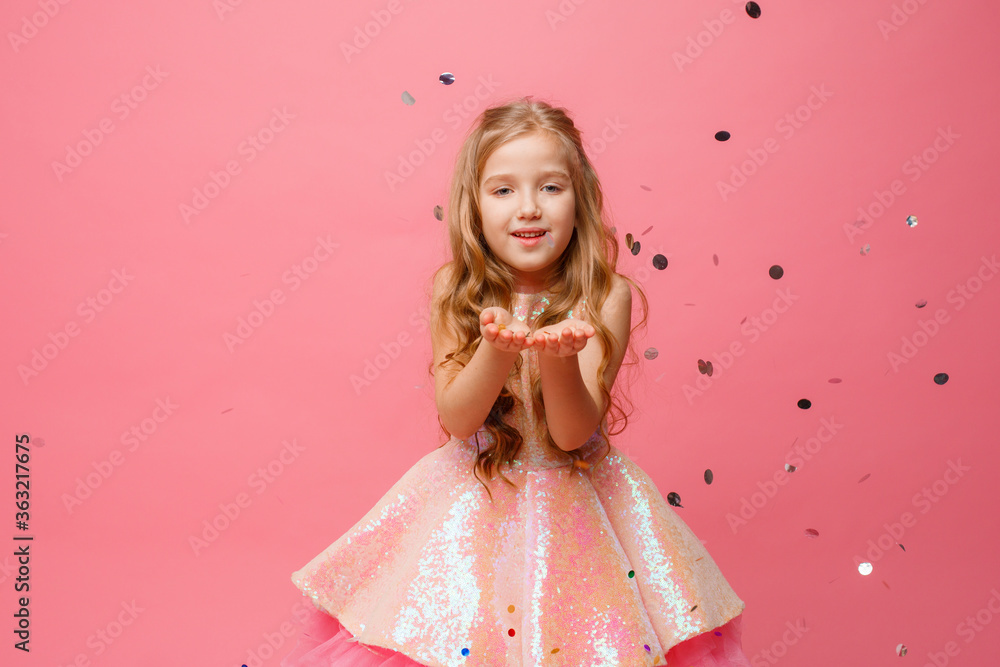 happy Little girl catches confetti on pink background, holiday concept happy Little girl catches confetti on pink background, holiday concept