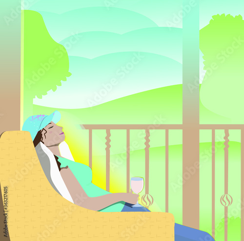 Girl resting in a chair on the terrace with a glass of wine