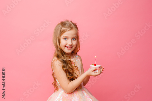 little girl with birthday cake on pink background