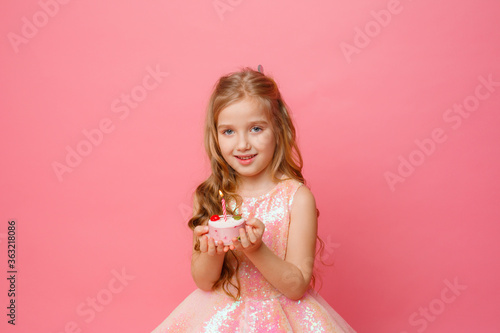 little girl with birthday cake on pink background