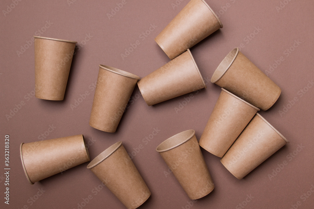 Fototapeta premium group of brown cardboard eco-friendly cups on brown background. top view. close-up