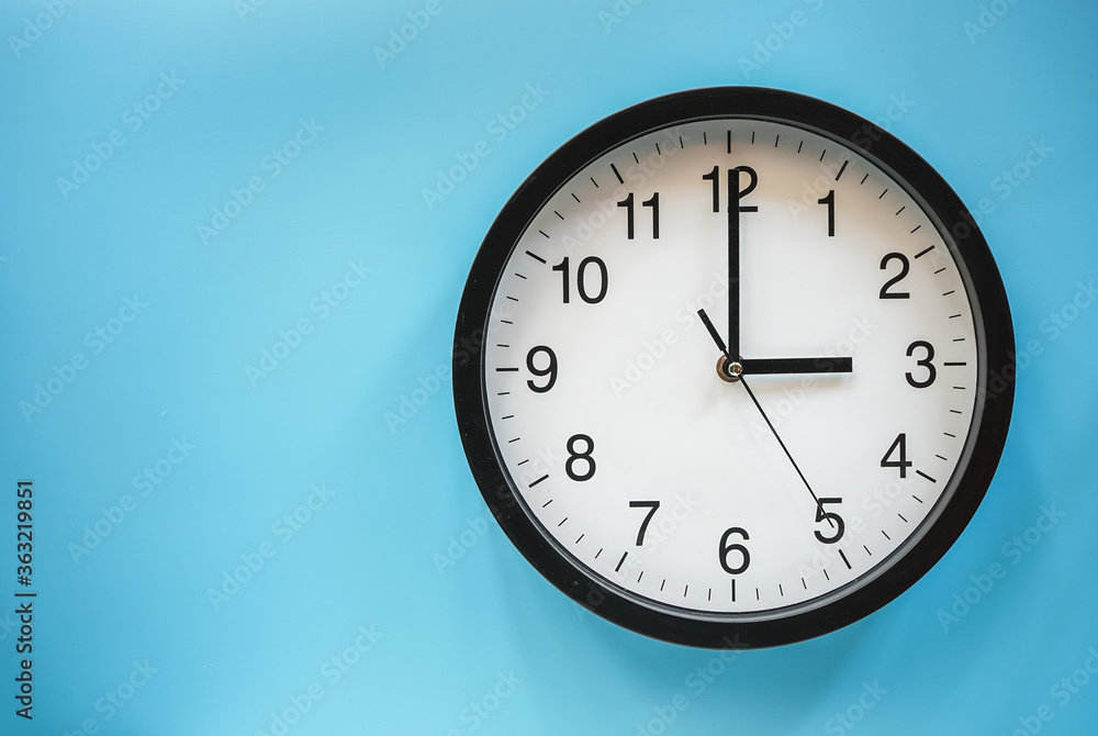 Classic black and white analog clock on blue background at Three o'clock with copy space Classic black and white analog clock on blue background at Three o'clock with copy space