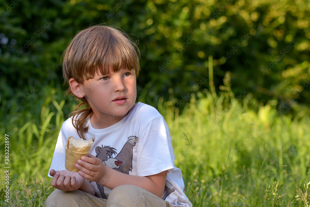 a boy eats ice cream in a city Park on a summer day