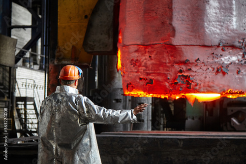 Worker blacksmith in protective clothing at the Forging shop