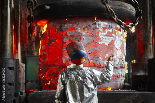 Worker blacksmith in protective clothing at the Forging shop