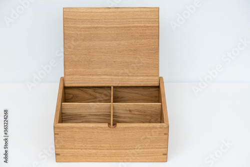 Large wooden box with a separator on a light mint background empty. Product Display Concept. Copy space. Oak box on the table, for installation. Vertical photo