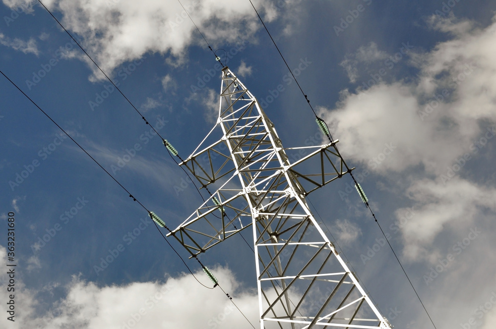 Power line mast against the blue sky.