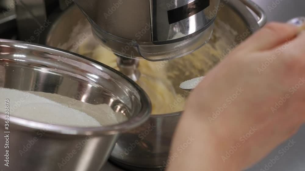 Close-up of butter and sugar being whipped in a food processor, a female cook pours sugar into a bowl. Slow motion. Close-up of butter and sugar being whipped in a food processor, a female cook pours sugar into a bowl. Slow motion.