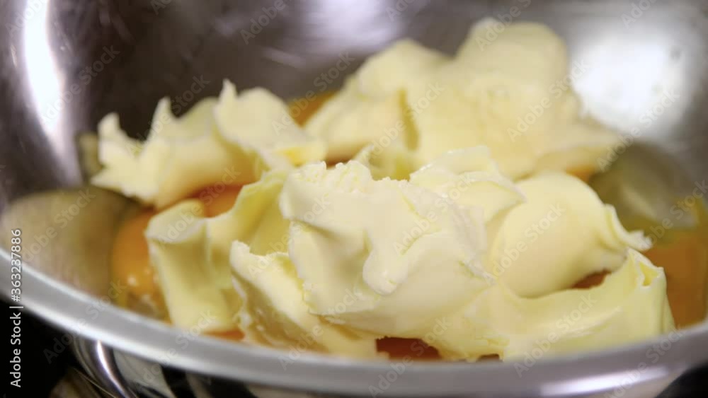 Baking of a cake, bread, biscuit or cookie. Close up of egg yolks and butter in a bowl. 4K Baking of a cake, bread, biscuit or cookie. Close up of egg yolks and butter in a bowl. 4K