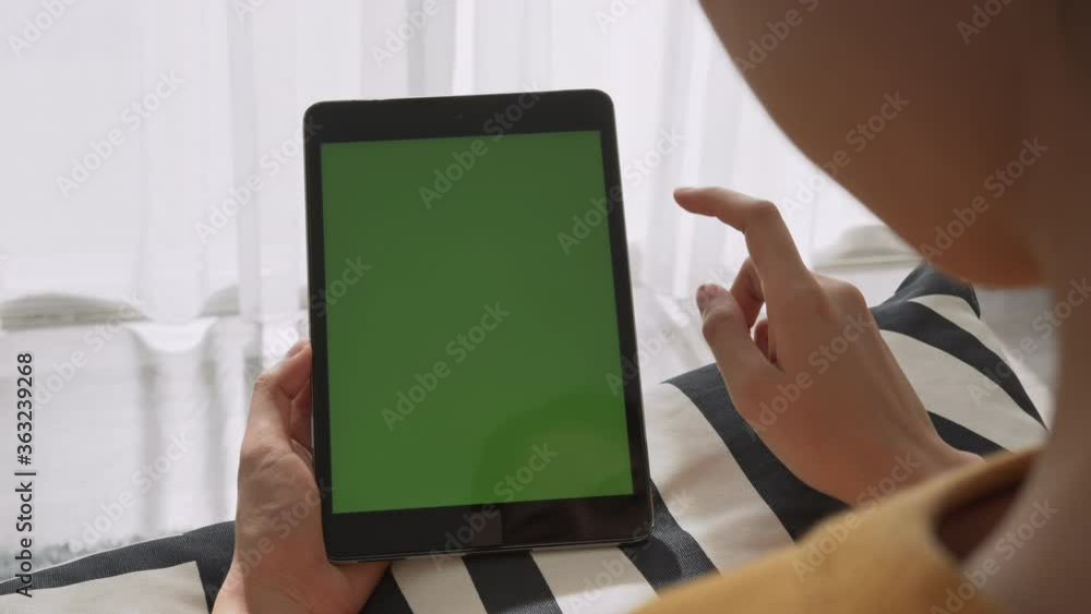 Woman holding digital tablet with green screen and touch device browsing Internet. Woman holding digital tablet with green screen and touch device browsing Internet.