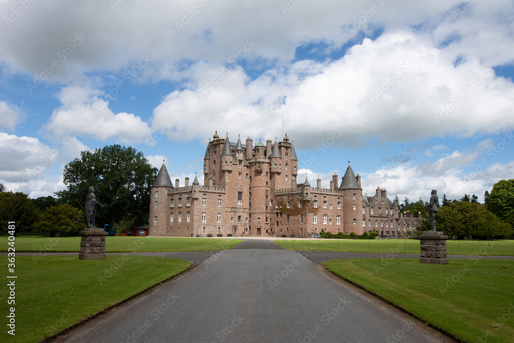 Blue sky over the driveway and trees on a summers day at Glamis Castle, Scotland.