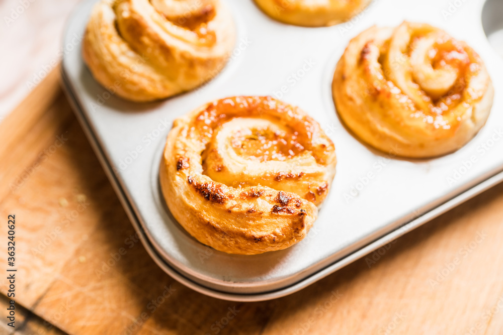 Fresh sweet bun with orange jam on the rustic wooden background. Selective focus. Fresh sweet bun with orange jam on the rustic wooden background. Selective focus.