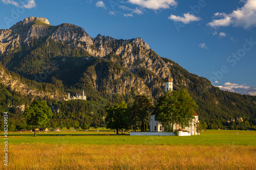 Neuschwanstein Castle and Sankt Coloman Church with Alps in the evening light