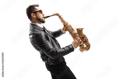 Profile shot of a musician in a leather jacket wearing sunglasses and playing a saxophone