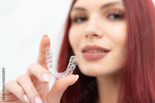 Girl with a beautiful smile shows a transparent mouth guard