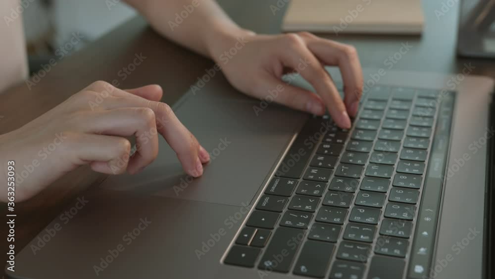 close-up of woman hands typing on laptop keyboard on the table. close-up of woman hands typing on laptop keyboard on the table.