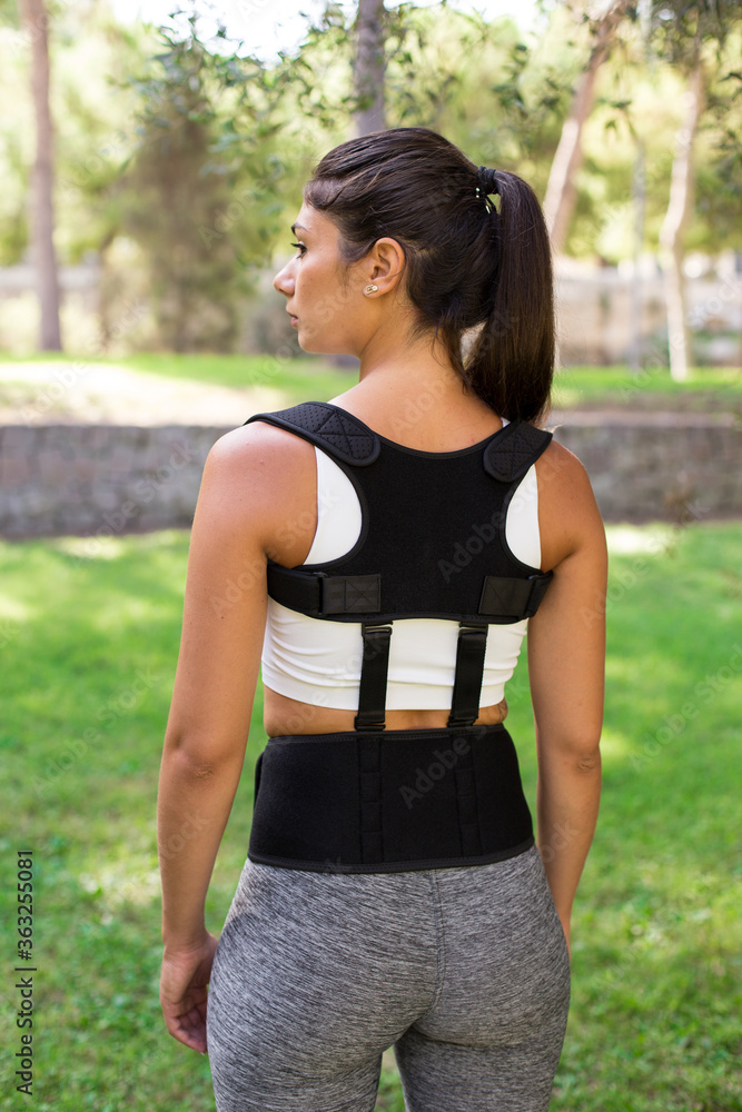 A beautiful girl in a park dressed in sportswear wearing Back posture corrector. Different views. Lifestyle. A beautiful girl in a park dressed in sportswear wearing Back posture corrector. Different views. Lifestyle.