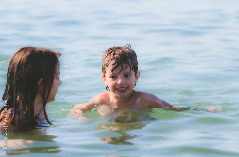 Brother and sister are swimming in the sea. Active summer vacation without gadgets. Travel destination Brother and sister are swimming in the sea. Active summer vacation without gadgets. Travel destination