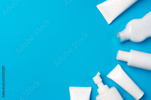 Bottles of sunscreen cream on blue background