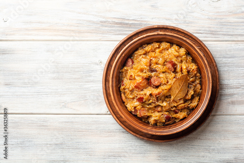 Traditional Polish dish Bigos in ceramic bowl on rustic wooden table photo