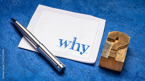 why question on a napkin with vintage letterpress wood type question mark against against blue bark paper, curiosity, explanation and reason concept