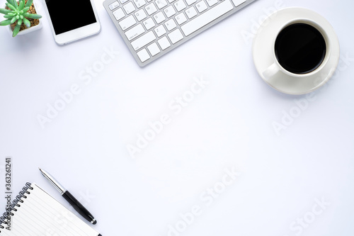 White office desk table with keyboard  notebook and coffee cup with equipment other office supplies. Business and finance concept.