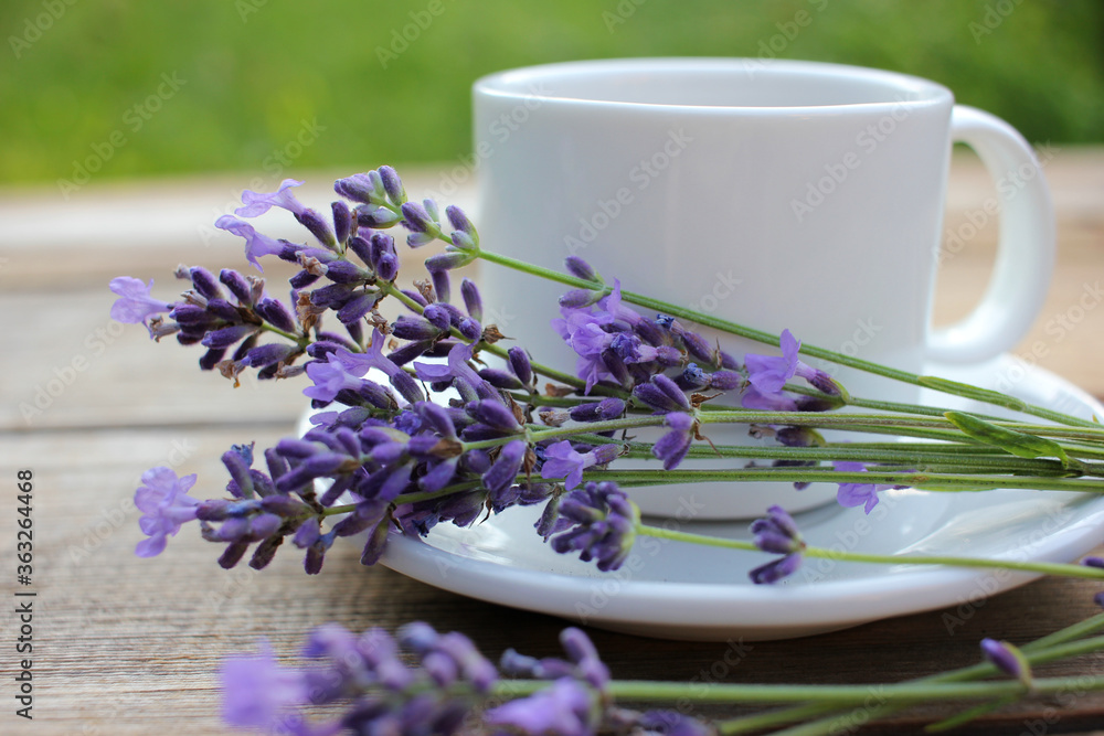 Cup of coffee with lavender flowers on wooden table background with copy space. Summer morning coffee. Top view
Cup of coffee with lavender flowers on wooden table background with copy space. Summer morning coffee. Top view