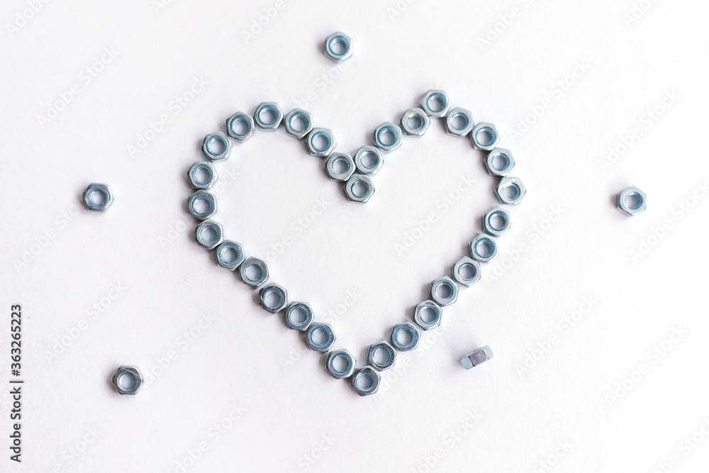 Heart laid out of bolts, nuts on a white background. Father's Day and wedding anniversary concept. Heart laid out of bolts, nuts on a white background. Father's Day and wedding anniversary concept.