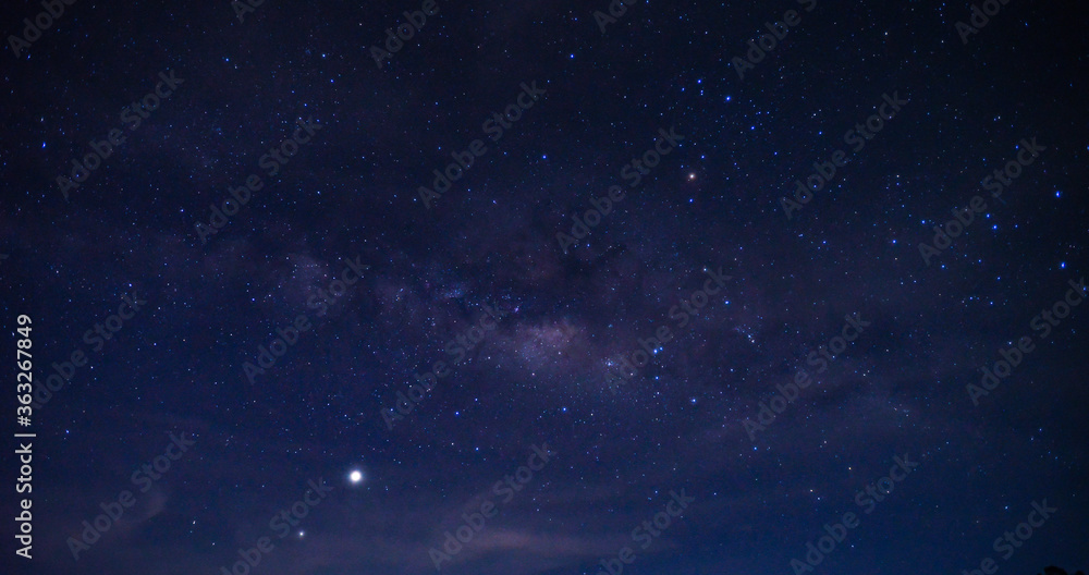 Obraz premium Panorama blue night sky milky way and star on dark background.Universe filled, nebula and galaxy with noise and grain.Photo by long exposure and select white balance.Dark night sky.