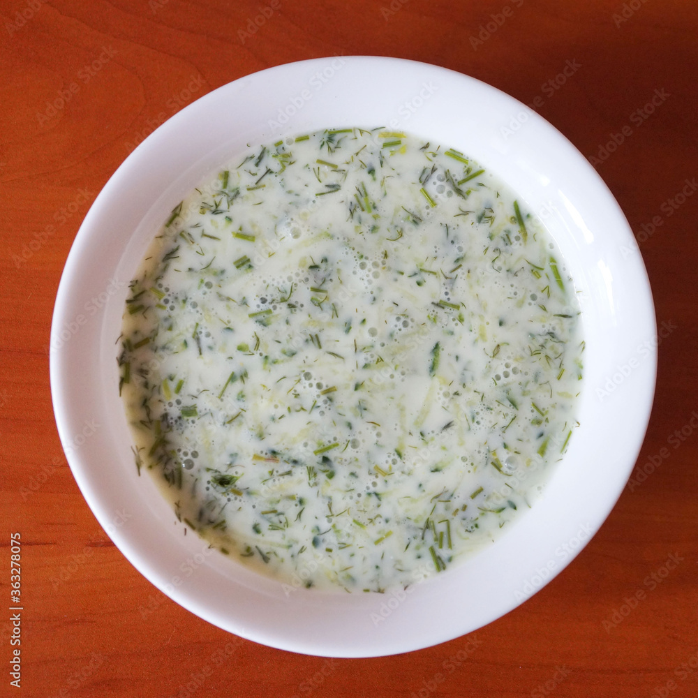 cucumber sour milk soup on a wooden table, top view. cucumber sour milk soup on a wooden table, top view.