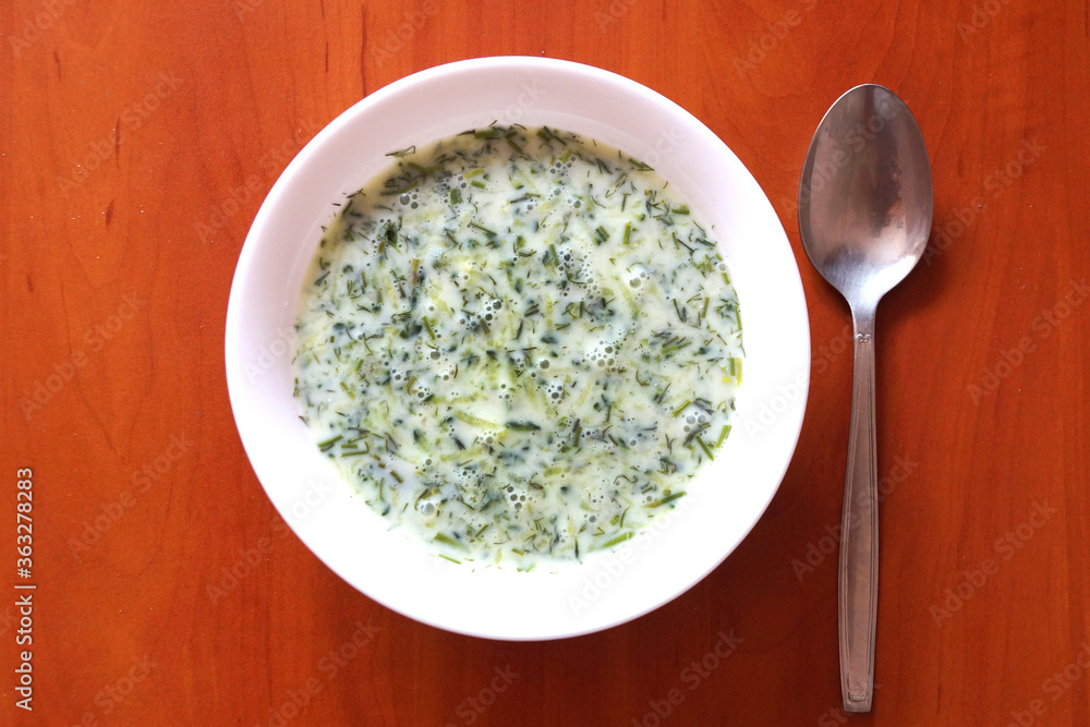 cucumber sour milk soup on a wooden table, top view. cucumber sour milk soup on a wooden table, top view.