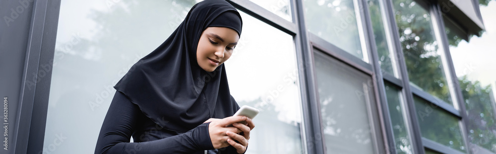 website header of young muslim woman using smartphone website header of young muslim woman using smartphone