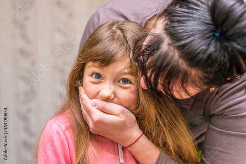 Slika na platnu Mom closes her daughter's hand with her hand so that she does not scream