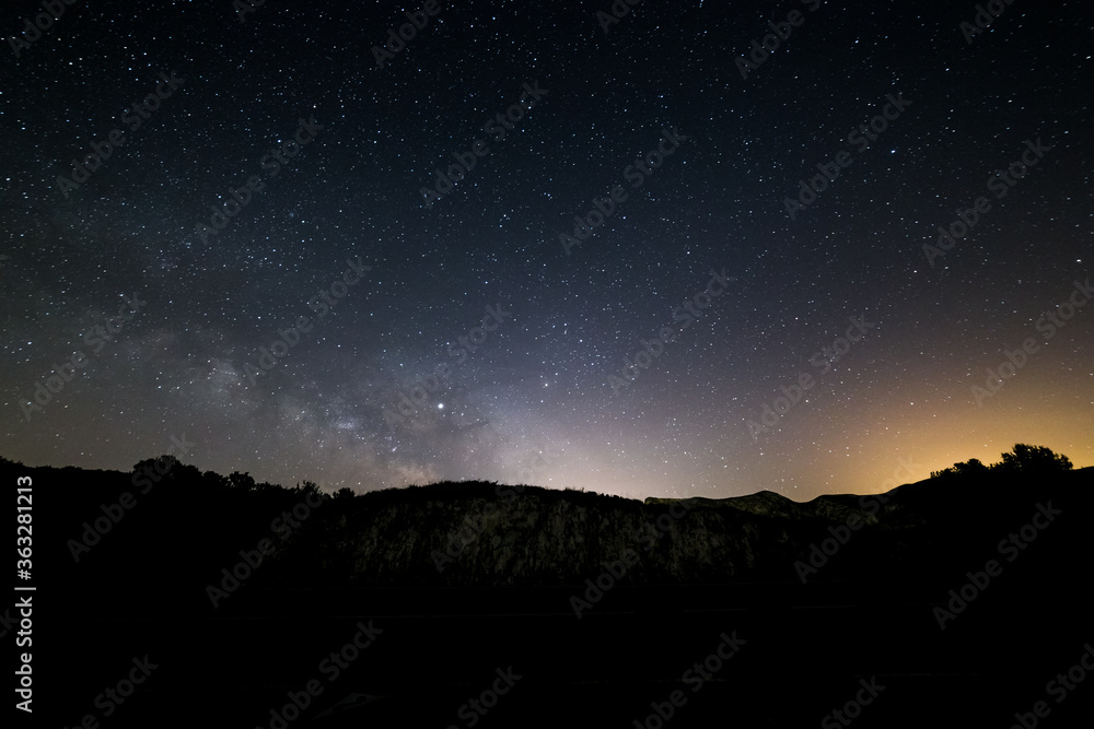 Milky way and stars with  light pollution above a mountain