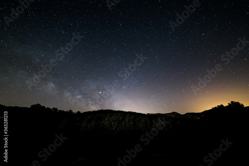 Milky way and stars with light pollution above a mountain