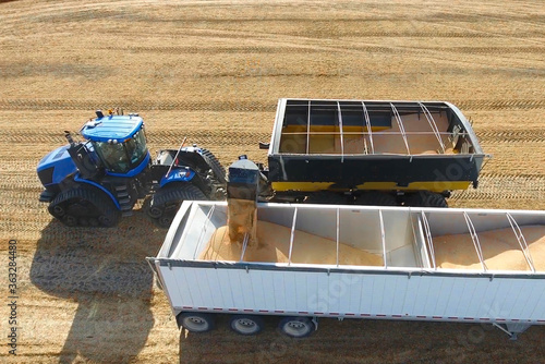 loading grain harvester into haulage track farming agriculture