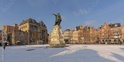 Friday market square, with statue of Jacob van Artevelde, medieval guild houses now housing bars and restaurants on a sunny winter day with snow in Ghent, Flanders, Belgium 