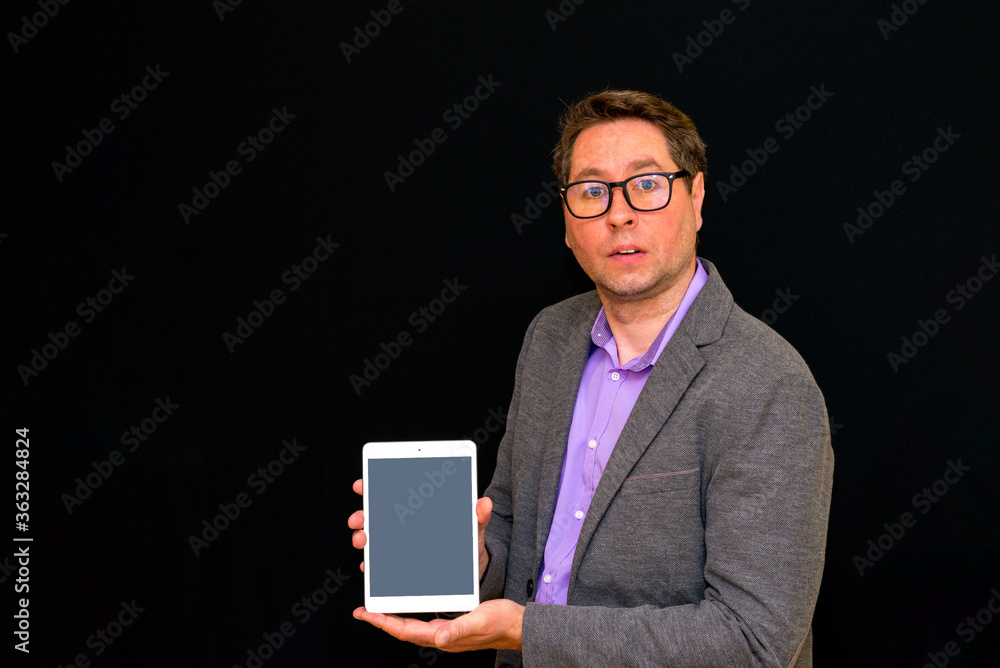 Middle age Business man holding and shows tablet pc with blank screen. Middle age Business man holding and shows tablet pc with blank screen.