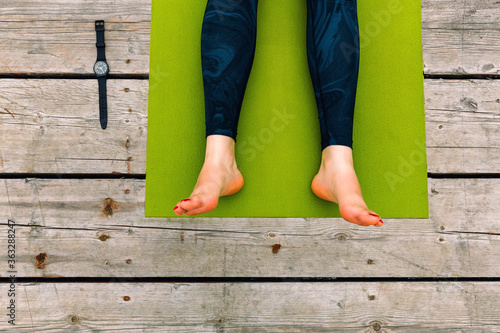 yoga practice. relax Wooden floor. Legs on Green carpet for sports. Outdoor