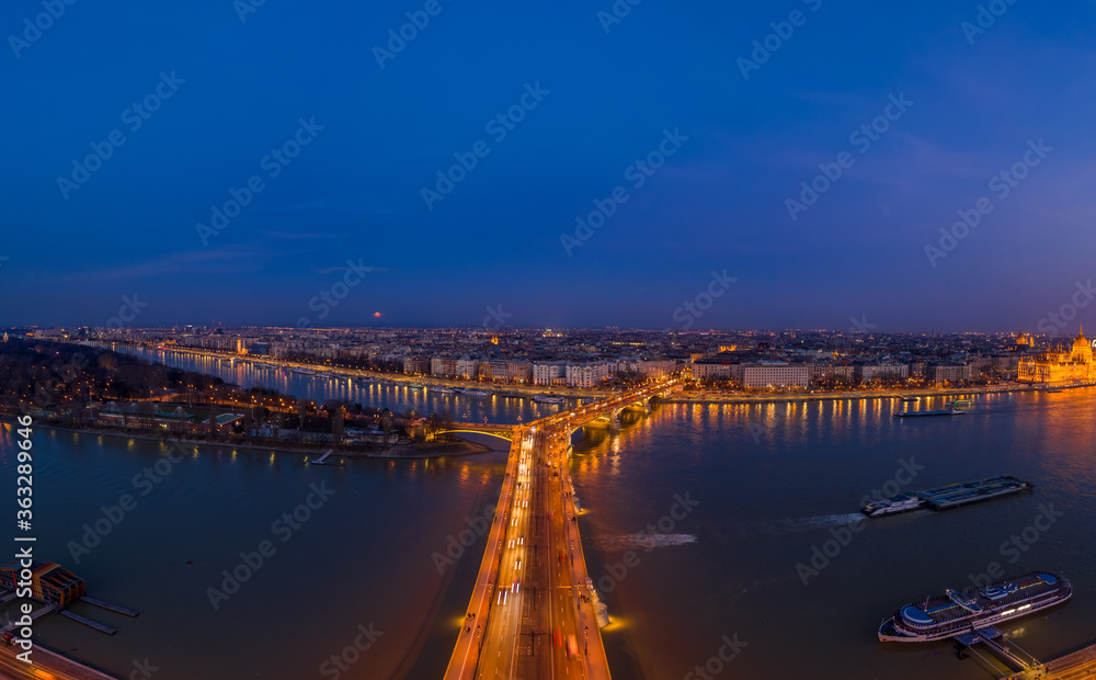Aerial drone shot of Margaret Bridge with lights on over Danube river during Budapest sunset Aerial drone shot of Margaret Bridge with lights on over Danube river during Budapest sunset