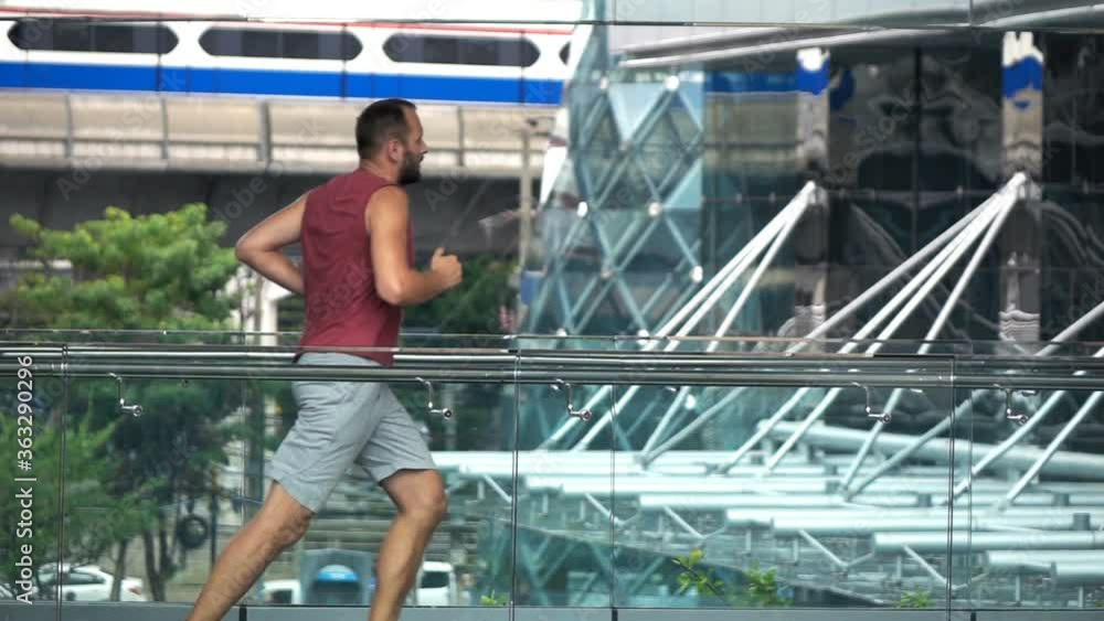 Young, sporty man jogging in the city, super slow motion Young, sporty man jogging in the city, super slow motion