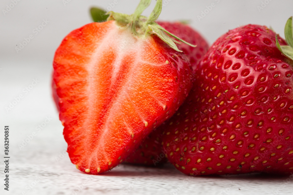 Fresh ripe perfect pieces strawberry on white marble background. Fresh strawberry as texture background. Natural food backdrop with red berries. Strawberries sale in a food market in summer.