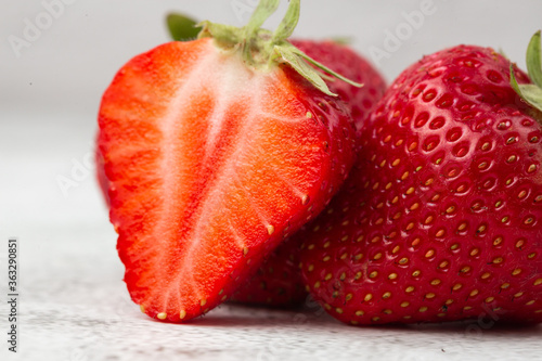 Obraz na płótnie Fresh ripe perfect pieces strawberry on white marble background. Fresh strawberry as texture background. Natural food backdrop with red berries. Strawberries sale in a food market in summer. w salonie