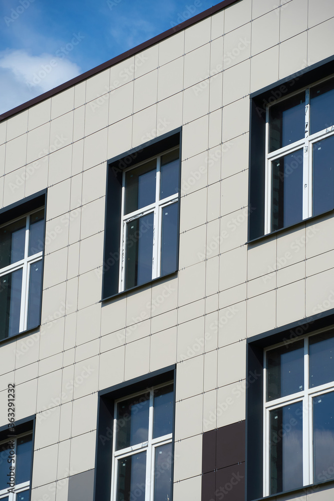 facade of a modern building on a bright Sunny day, siding and Windows, beautiful exterior of the new building