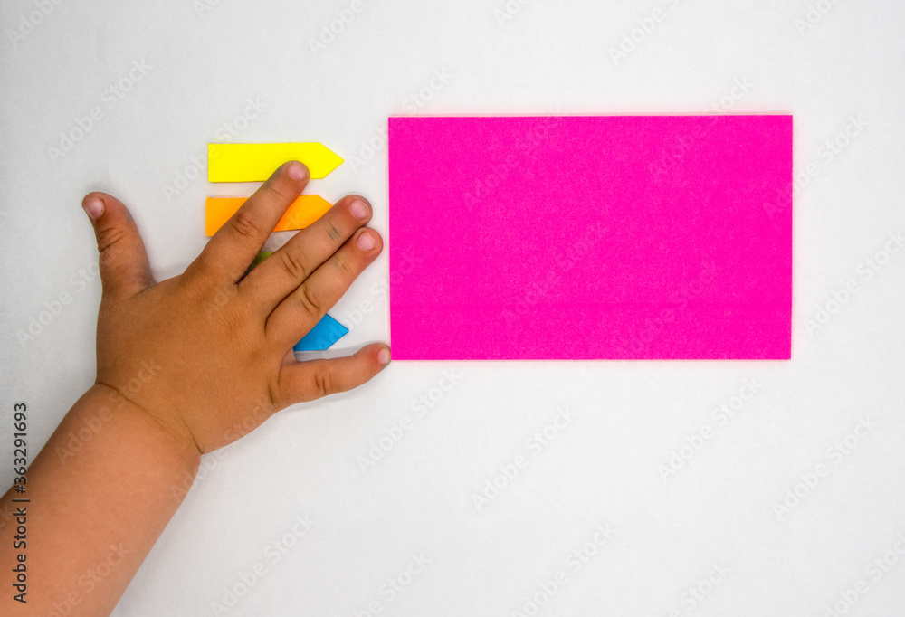Children's hand stained in paint on a table with colored paper. Kindergarten, kindergarten, preschool education. Flat lay, copy space, top view. Children's hand stained in paint on a table with colored paper. Kindergarten, kindergarten, preschool education. Flat lay, copy space, top view.