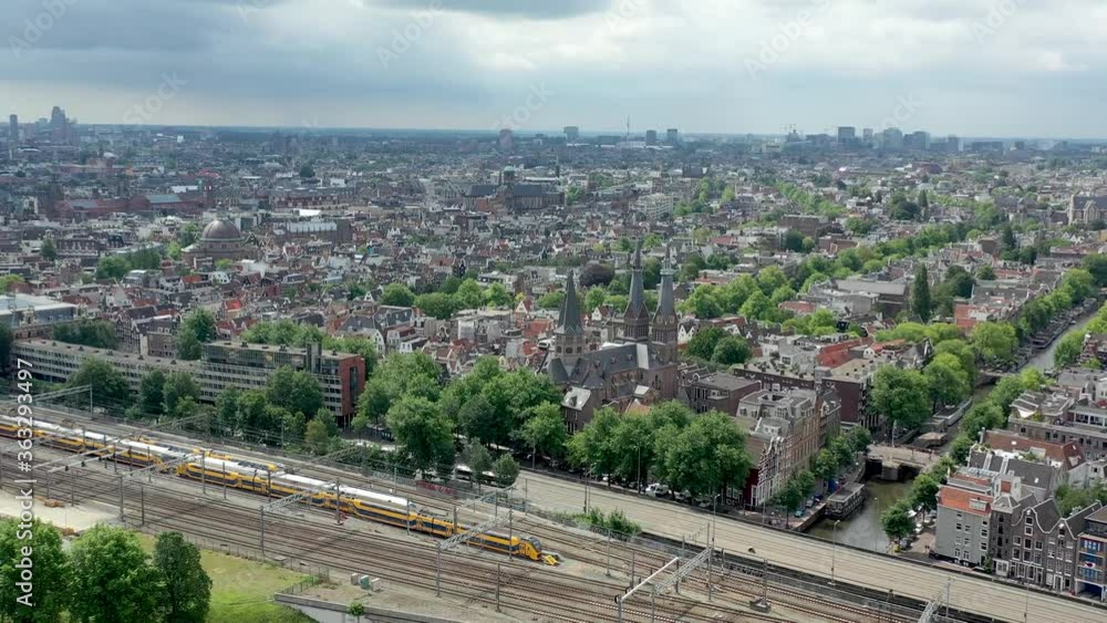 Beautiful aerial Amsterdam view from above with narrow canals, streets, railroad and architecture.